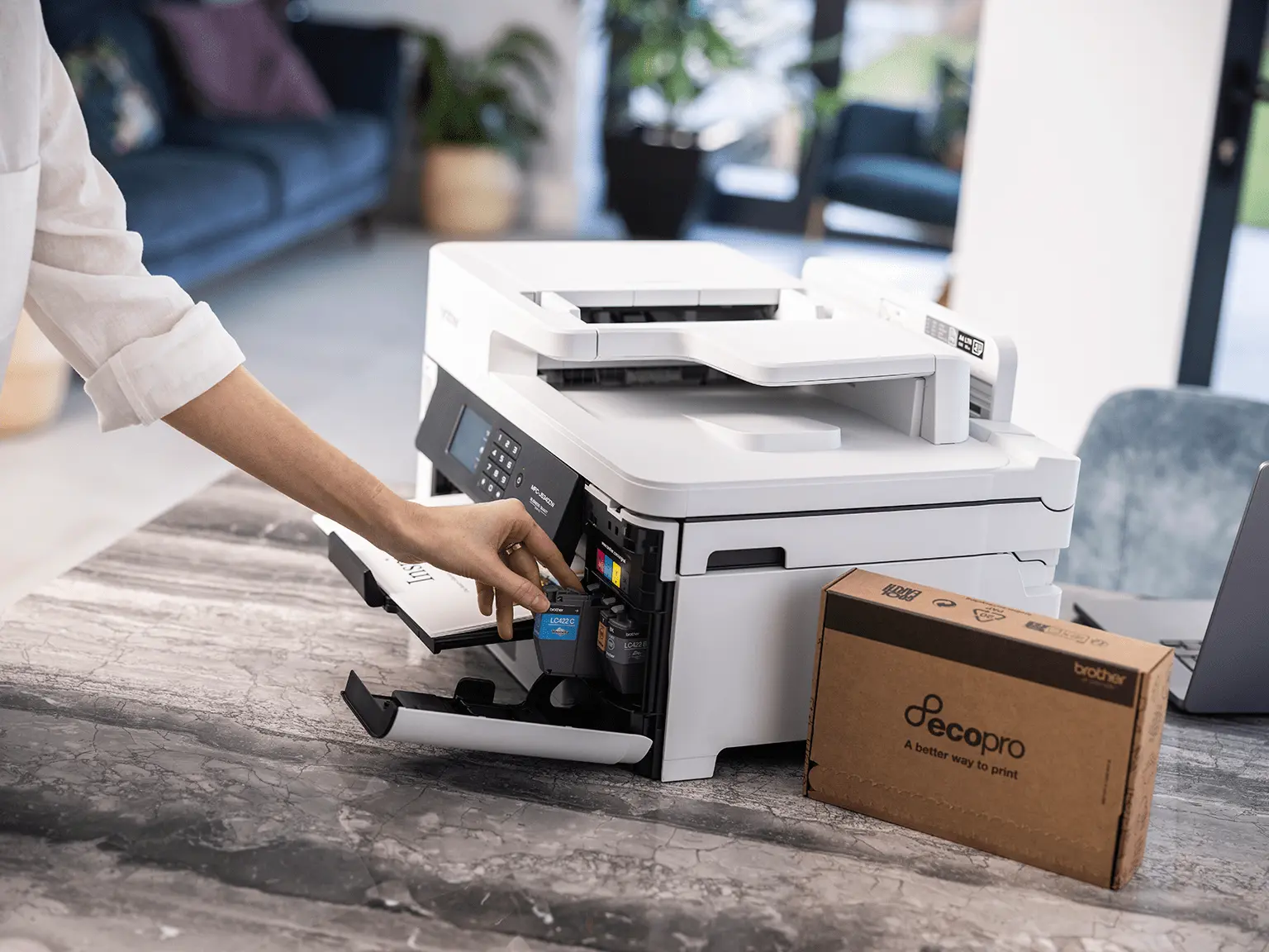 A woman putting Brother cartridges from an EcoPro subscription into her Brother printer