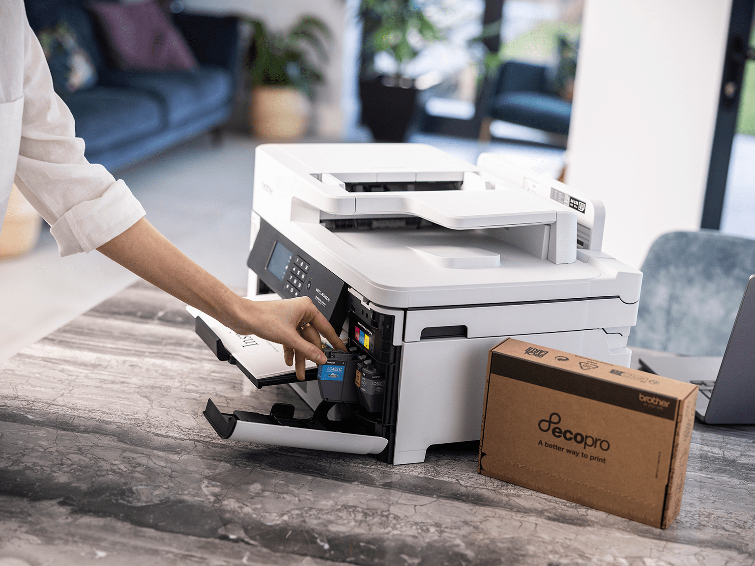 A woman putting Brother cartridges from an EcoPro subscription into her Brother printer