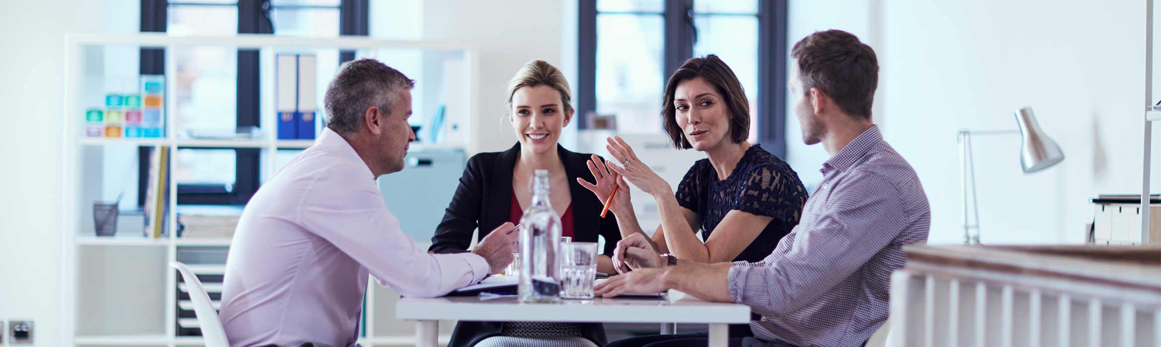 Two men and two women working around a table