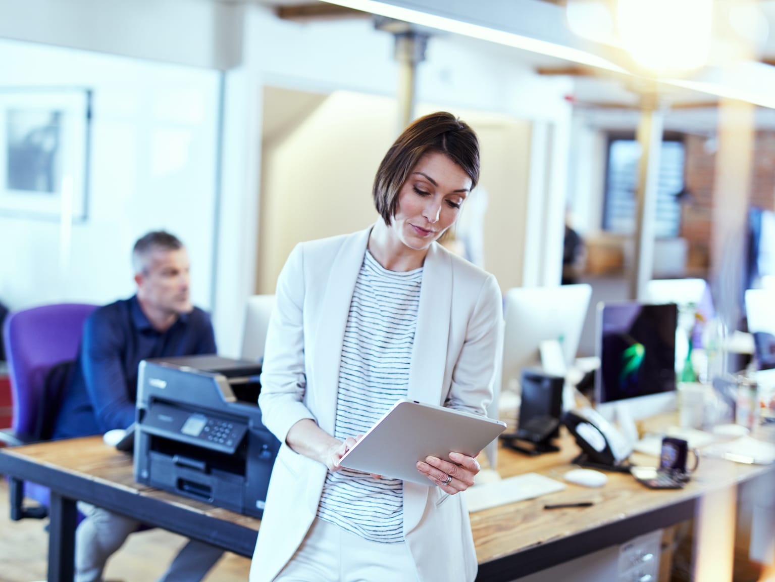 A lady printing a document from a tablet device in a small office environment