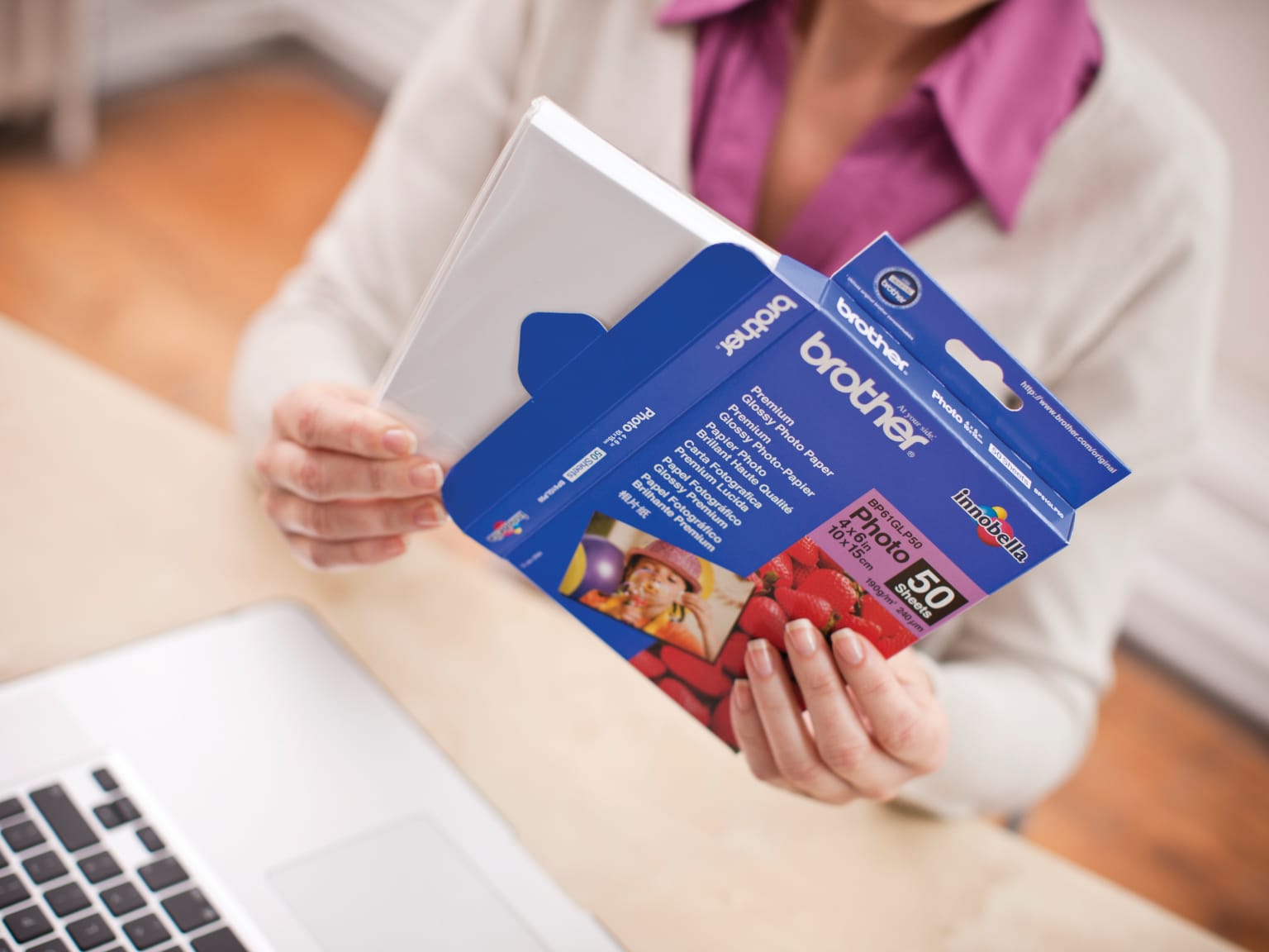 A woman removing a ream of paper from packaging