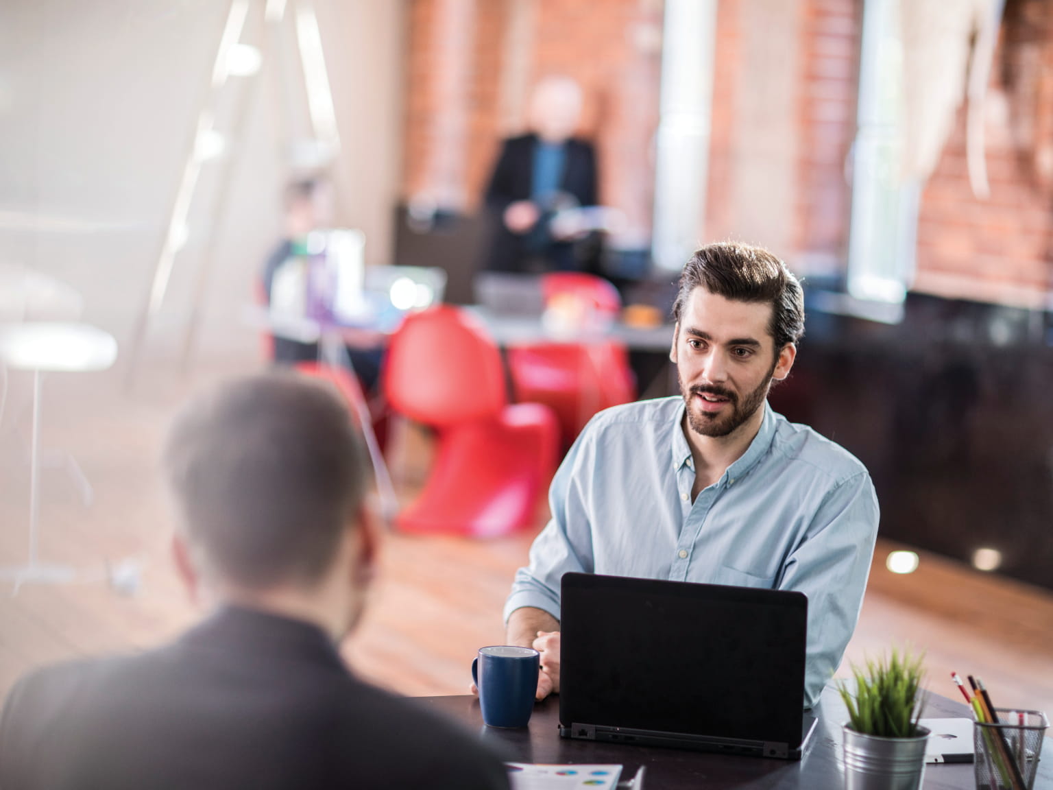 A supplier discussing a service level agreement with a customer across a desk in an office environment