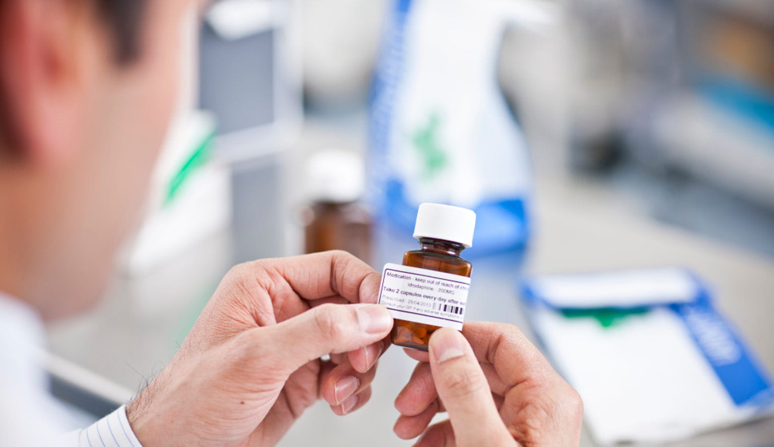 Hombre pegando etiqueta en frasco de medicamentos